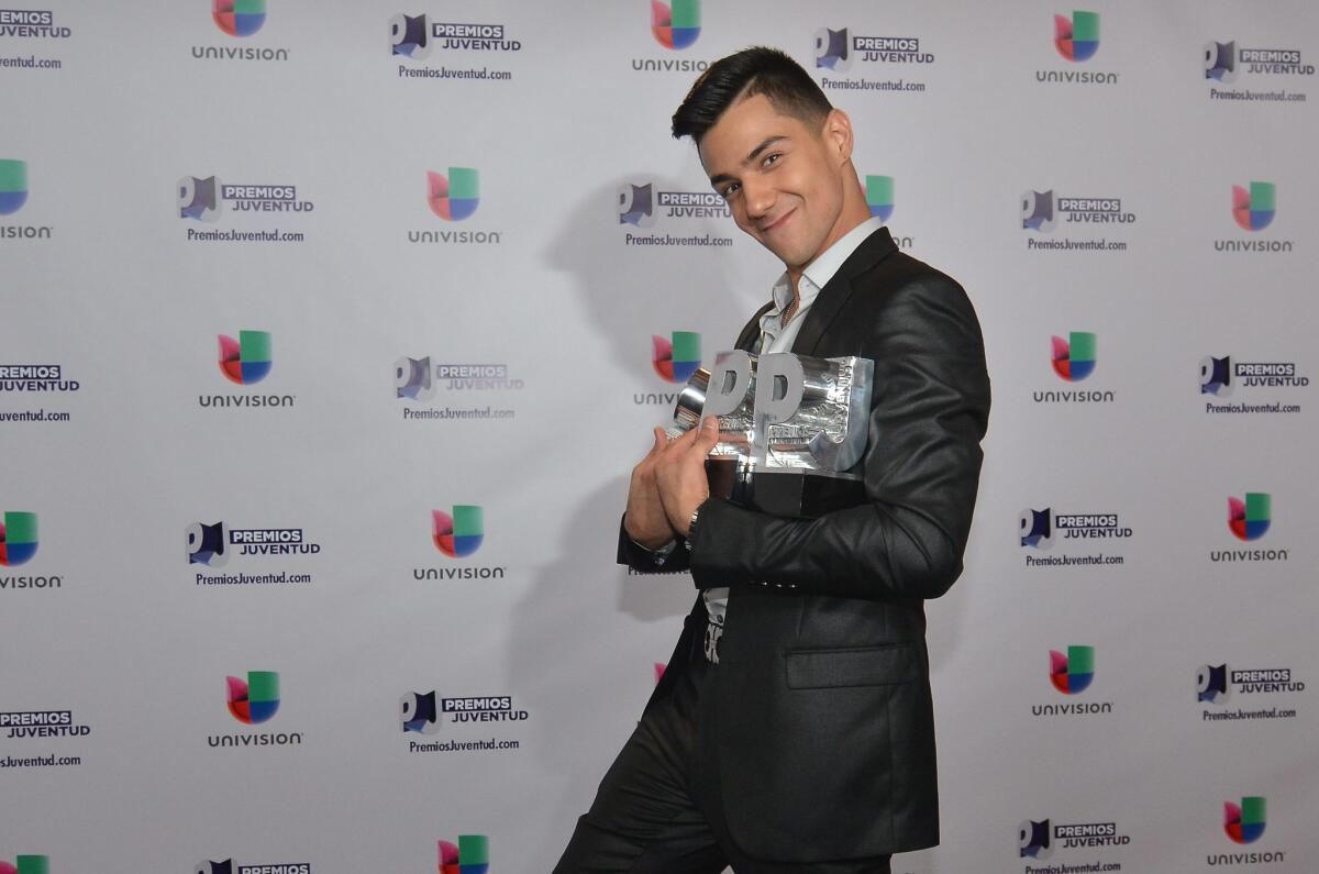 Luis Coronel posa con sus premios "Just Play It All" por "Quiero Ser Tu Dueño" y "Red Hot Artist", y el galardón "My Regional Mexican Artist" durante los Premios Juventud 2015.