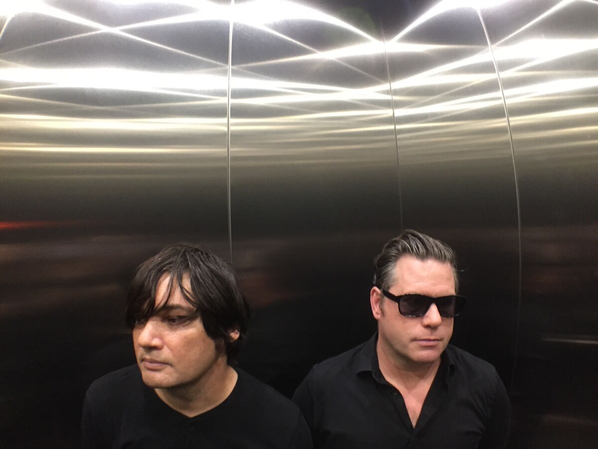 A close up photo of two men in an elevator
