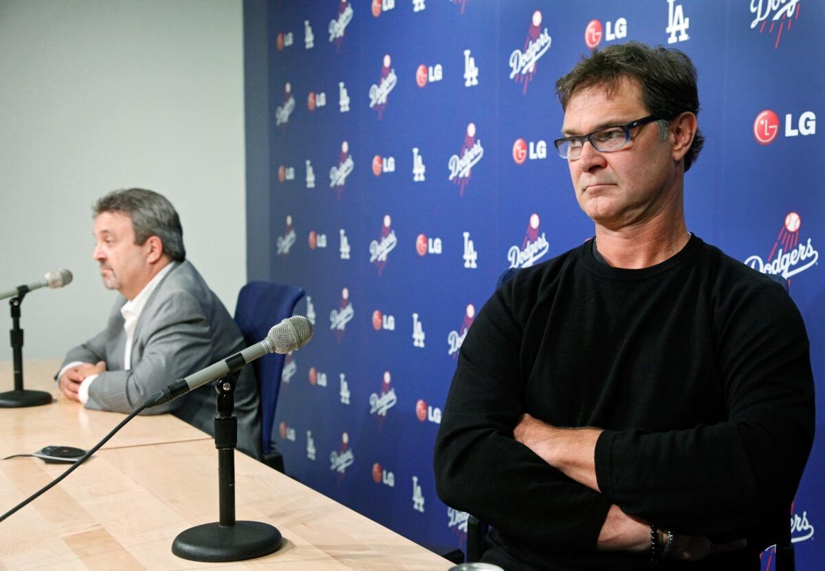 Dodgers General Manager Ned Colletti, left, and Manager Don Mattingly speak to the media Monday at Dodger Stadium.