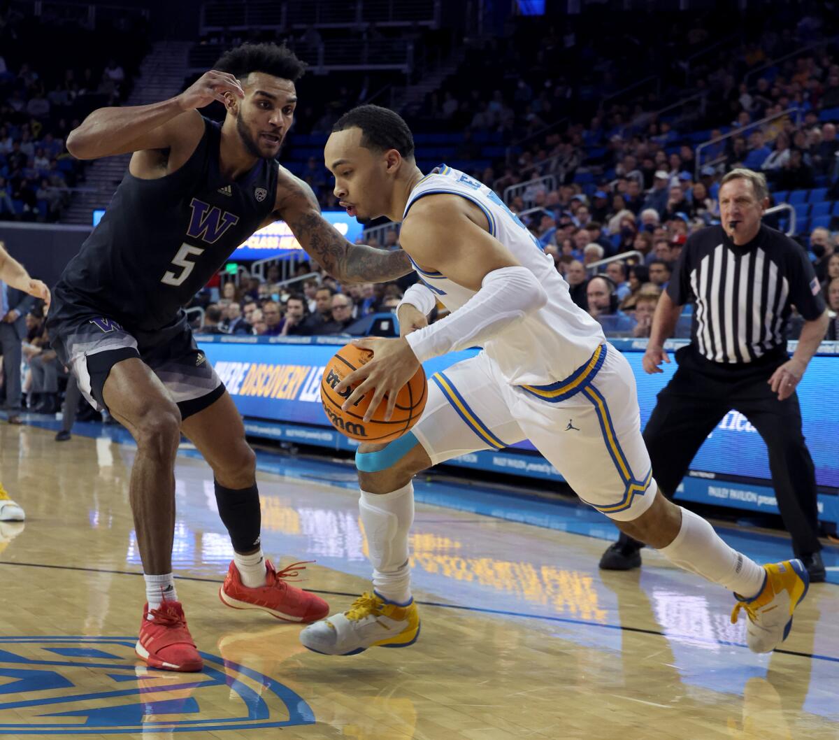 UCLA guard Amari Bailey, right, drives to the basket against Washington guard Jamal Bey in the second half.