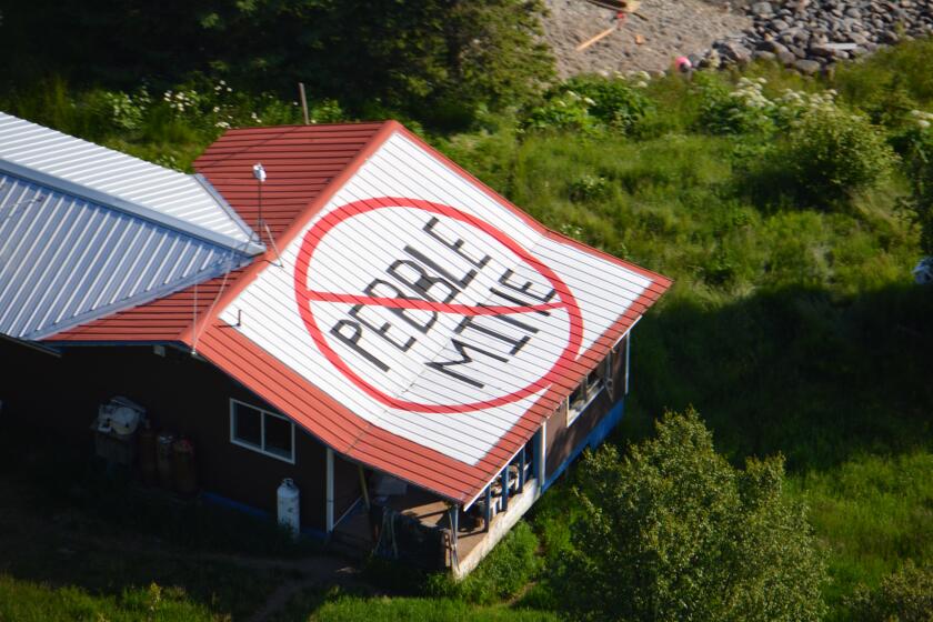 A rooftop symbol tells anyone flying by just what Pedro Bay, an Alaskan village accessible only by air and boat, thinks of the proposed Pebble Mine. The Native corporation that owns land around the remote village has created problems for Pebble Limited Partnership by refusing to let the mining company put though a road and pipeline.