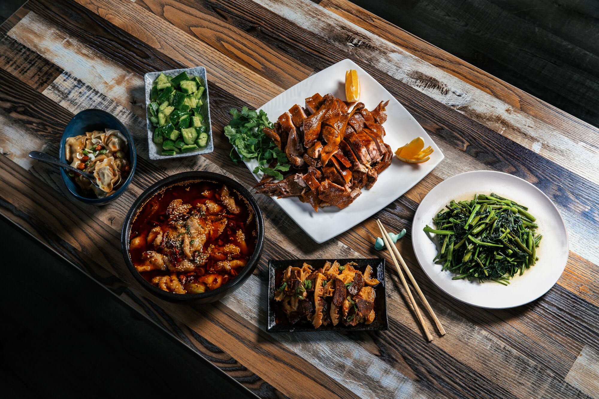 Overhead view of six dishes on a table with chopsticks