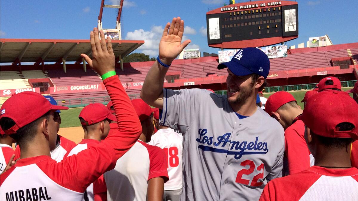 Dodgers pitcher Clayton Kershaw high-fives youth players after a clinic in Cuba.