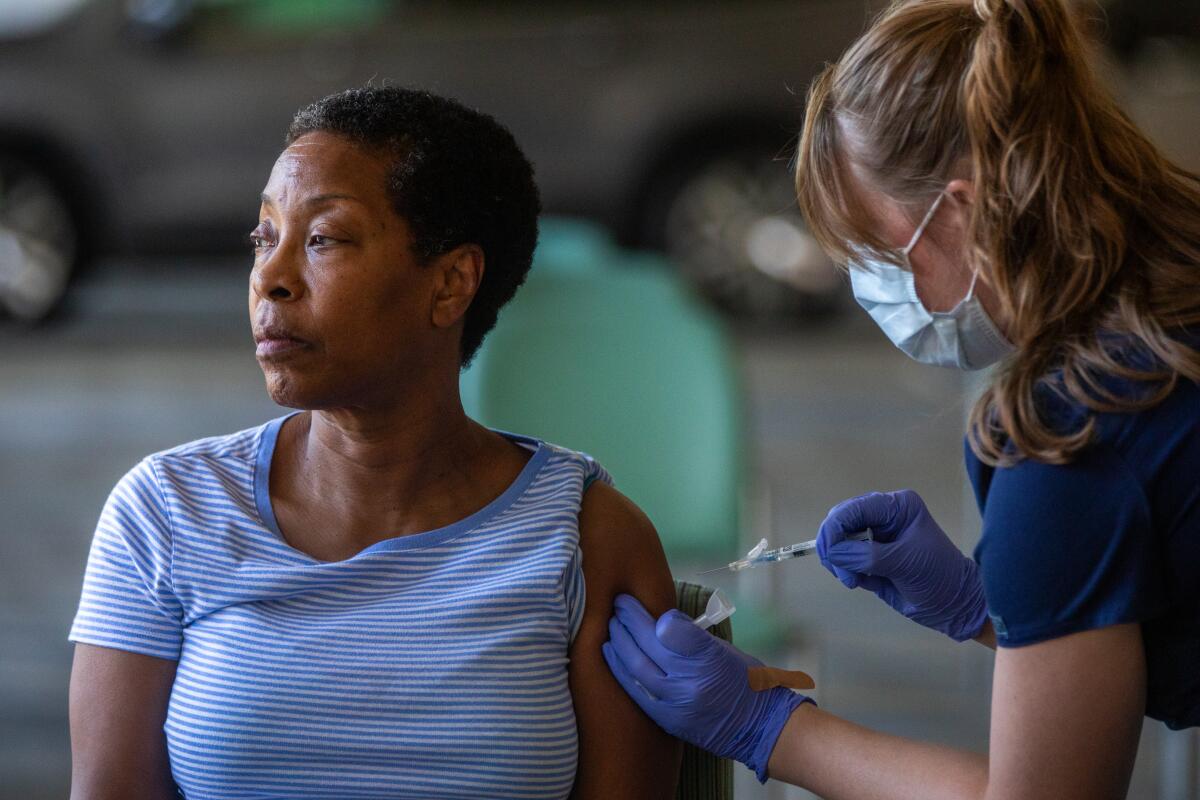 A woman receives a vaccination. 