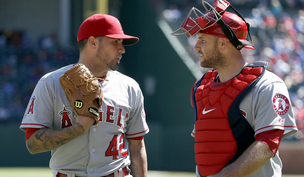 Angels catcher Chris Iannetta talks to pitcher Hector Santiago during a game April 15.