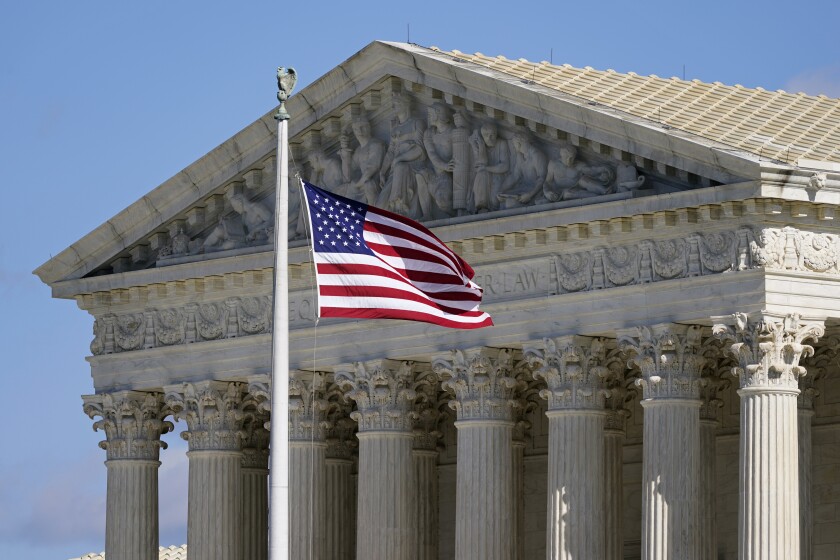 FILE - An American flag waves in front of the Supreme Court building on Capitol Hill in Washington, Nov. 2, 2020. (AP Photo/Patrick Semansky, File)