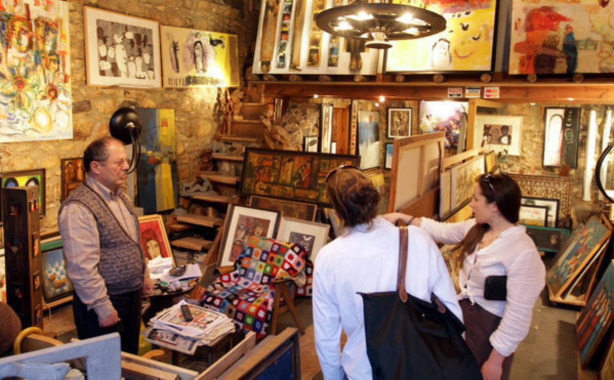 Tourists shop for paintings at an art store in Damascus, the Syrian capital.