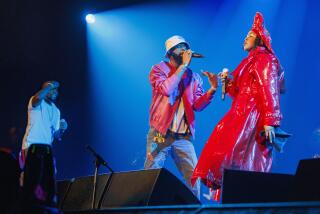 Wyclef Jean, from left, Pras, and Lauryn Hill of the Fugees perform together onstage