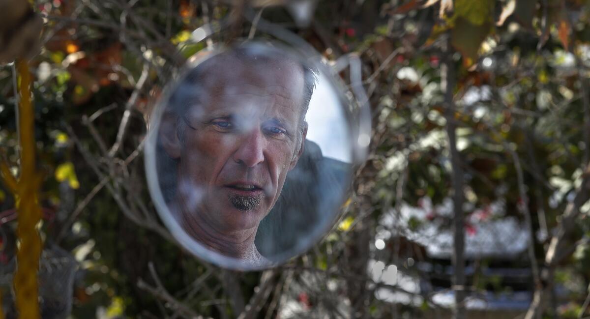 Homeless veteran Larry Ford is reflected in a mirror hanging inside his camp. Homeless people are packing their belongings in preparation for Friday’s eviction.
