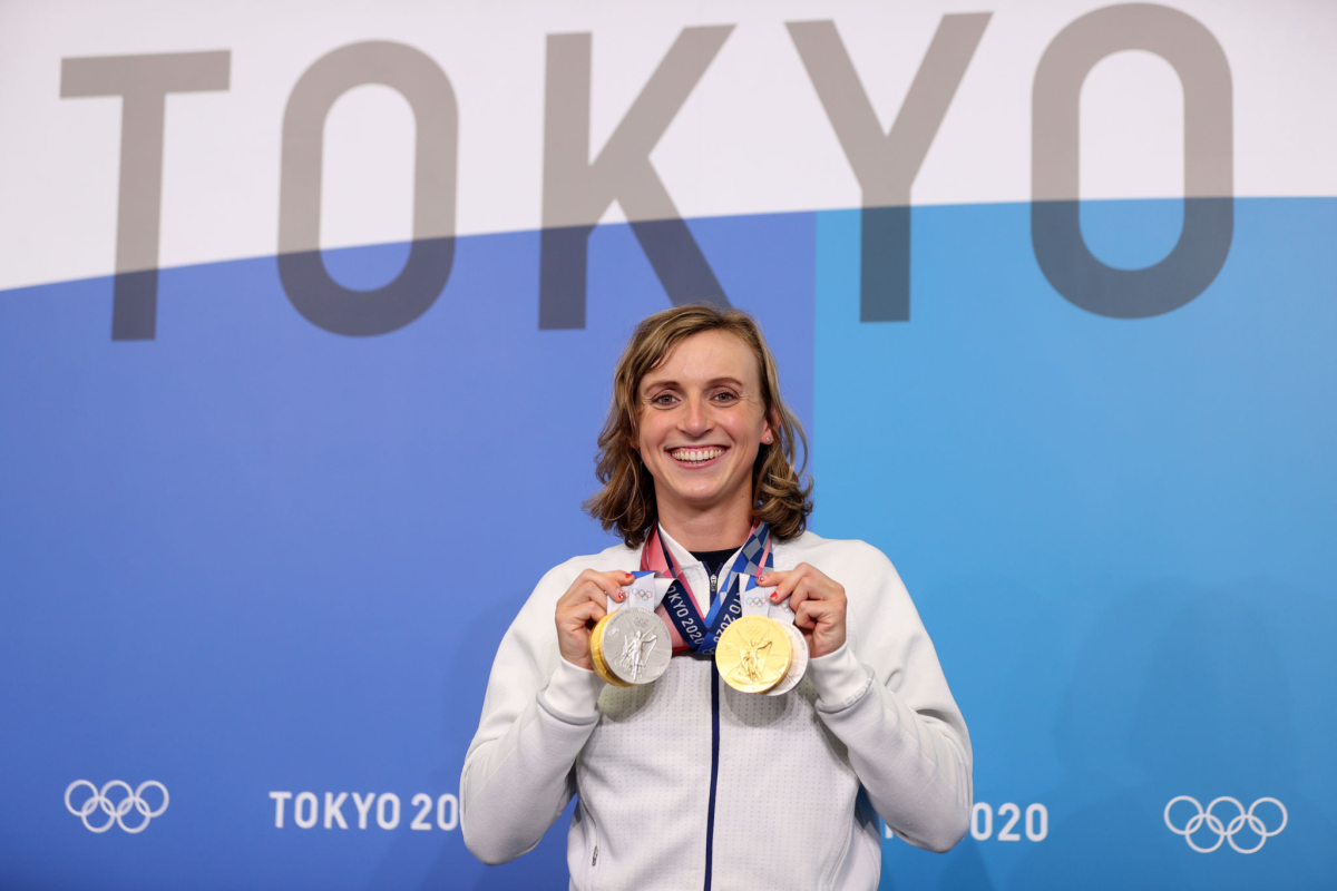 Katie Ledecky holds up her gold and silver medals at the Tokyo Olympics