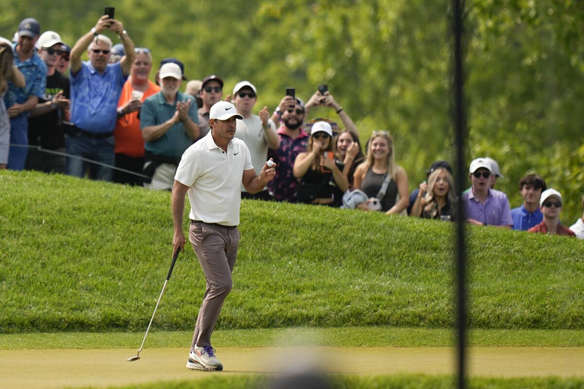 Brooks Koepka waves after his putt on the third hole during the final round of the PGA Championship.