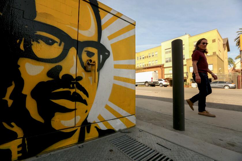 A pedestrian walks past a mural of famed Filipino-American labor organizer Larry" Dulay Itliong 