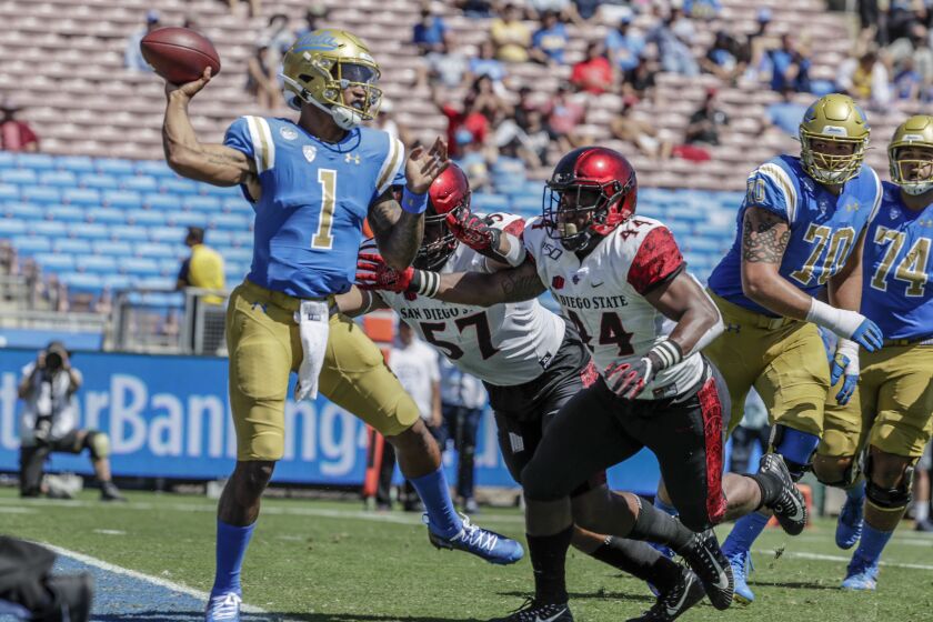 PASADENA, CA, SATURDAY, SEPTEMBER 7, 2019 - UCLA quarterback Dorian Thompson-Robinson passes under pressure from San Diego State rushers Kyahva Tezino and Keshawn Banks during second quarter action at the Rose Bowl. (Robert Gauthier/Los Angeles Times)