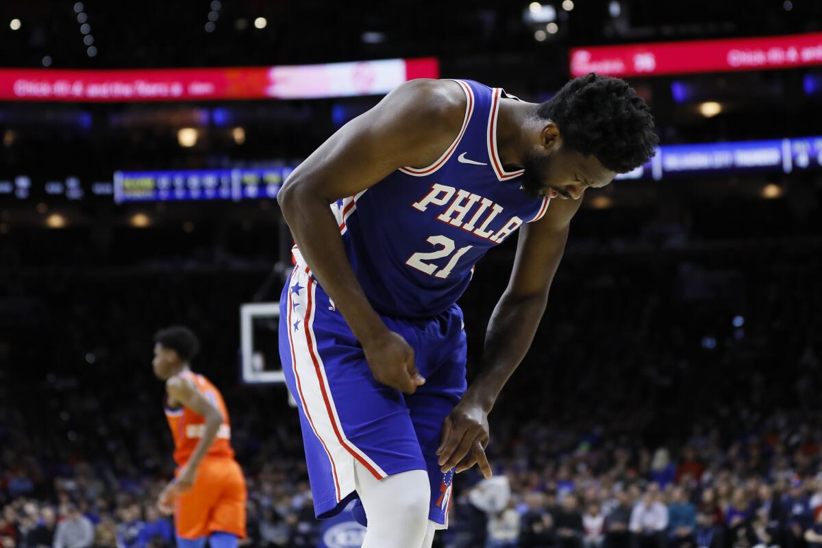 Philadelphia center Joel Embiid writhes in pain after injuring his left ring finger during a game Jan. 6, 2020.