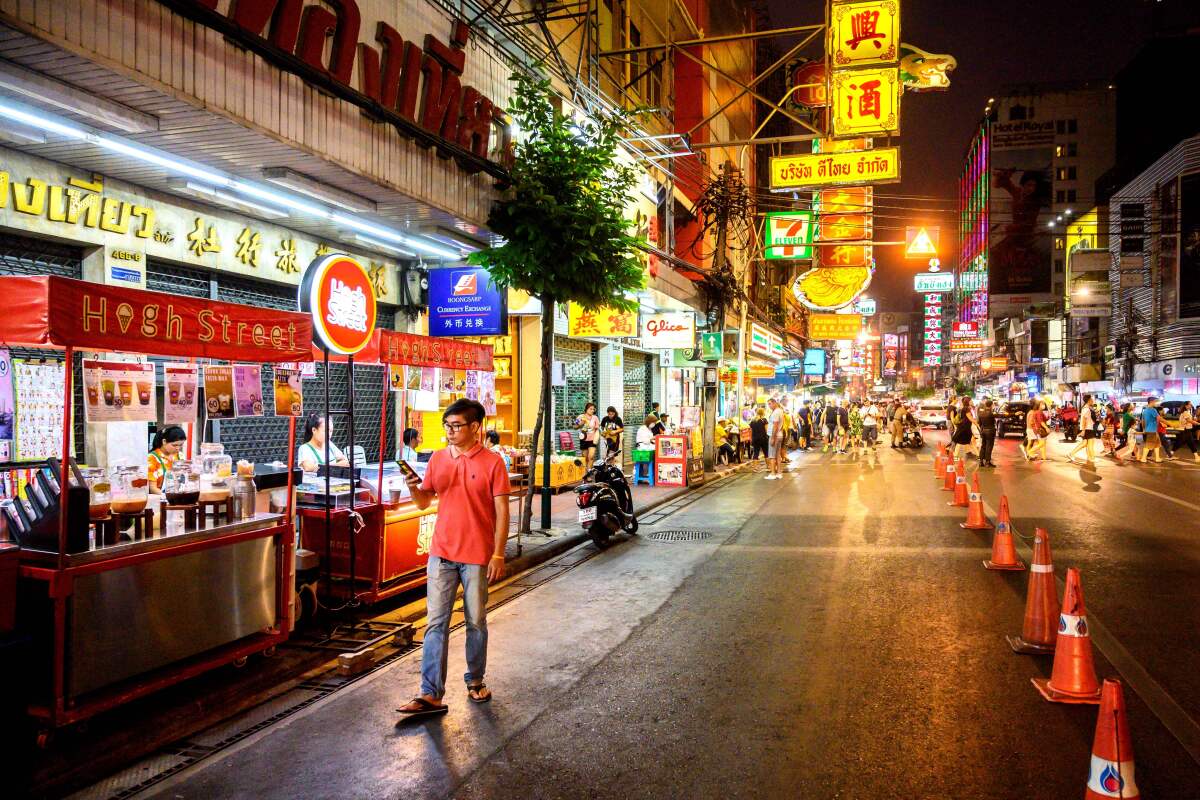 A tourist walks through a nearly empty Chinatown in Bangkok, Thailand.