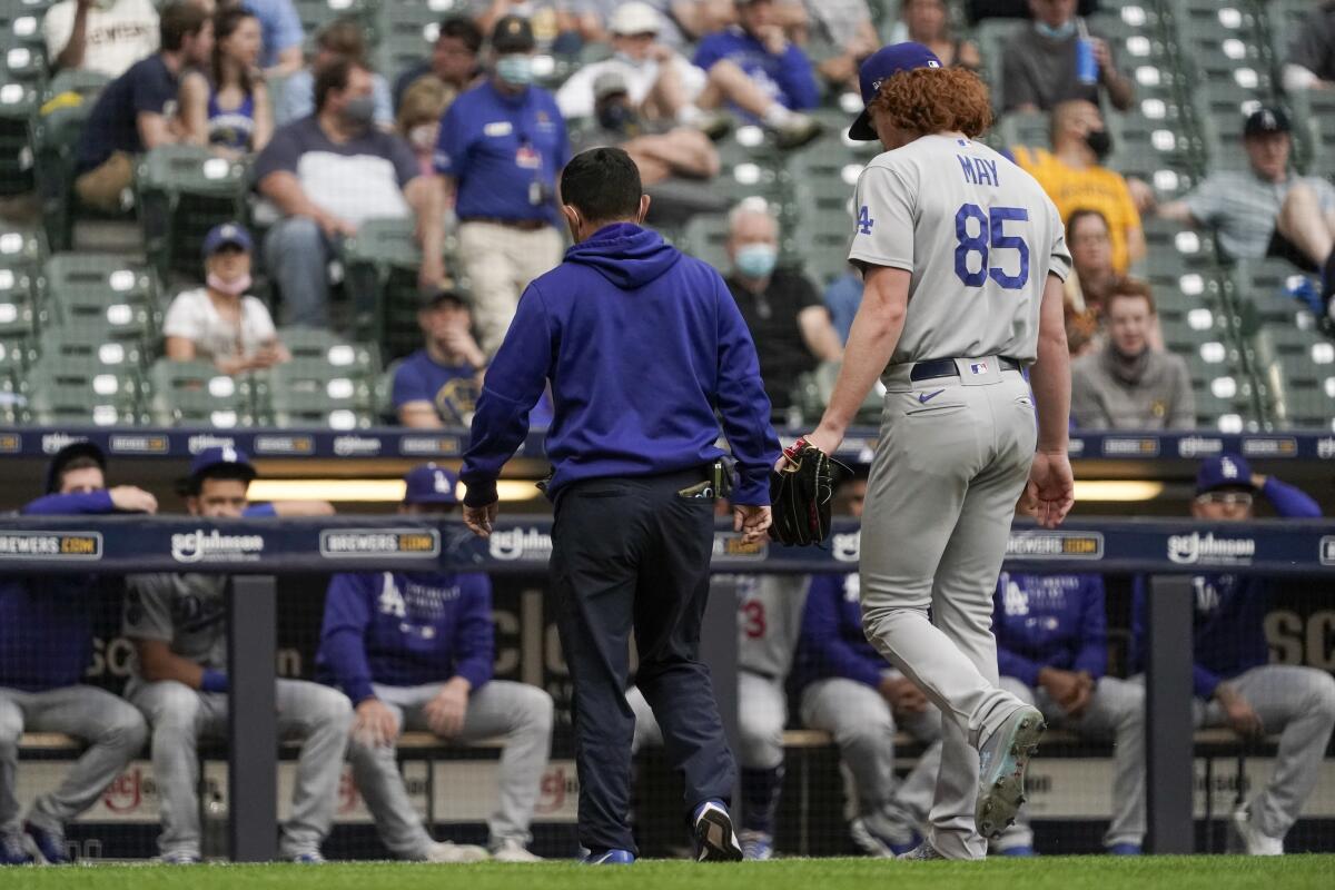 Dodgers pitcher Dustin May walks off the field after suffering an arm injury against the Milwaukee Brewers on Saturday.