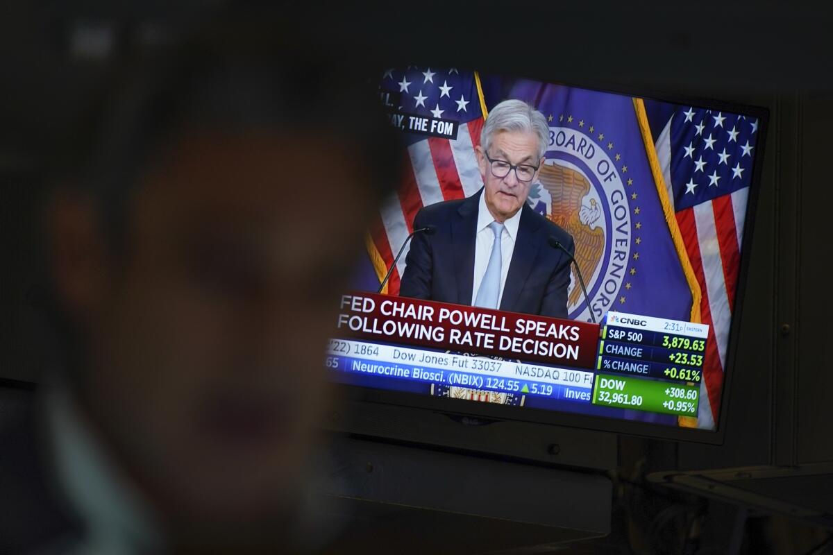 A monitor shows Federal Reserve Chair Jerome Powell speaking  as traders work at the New York Stock Exchange