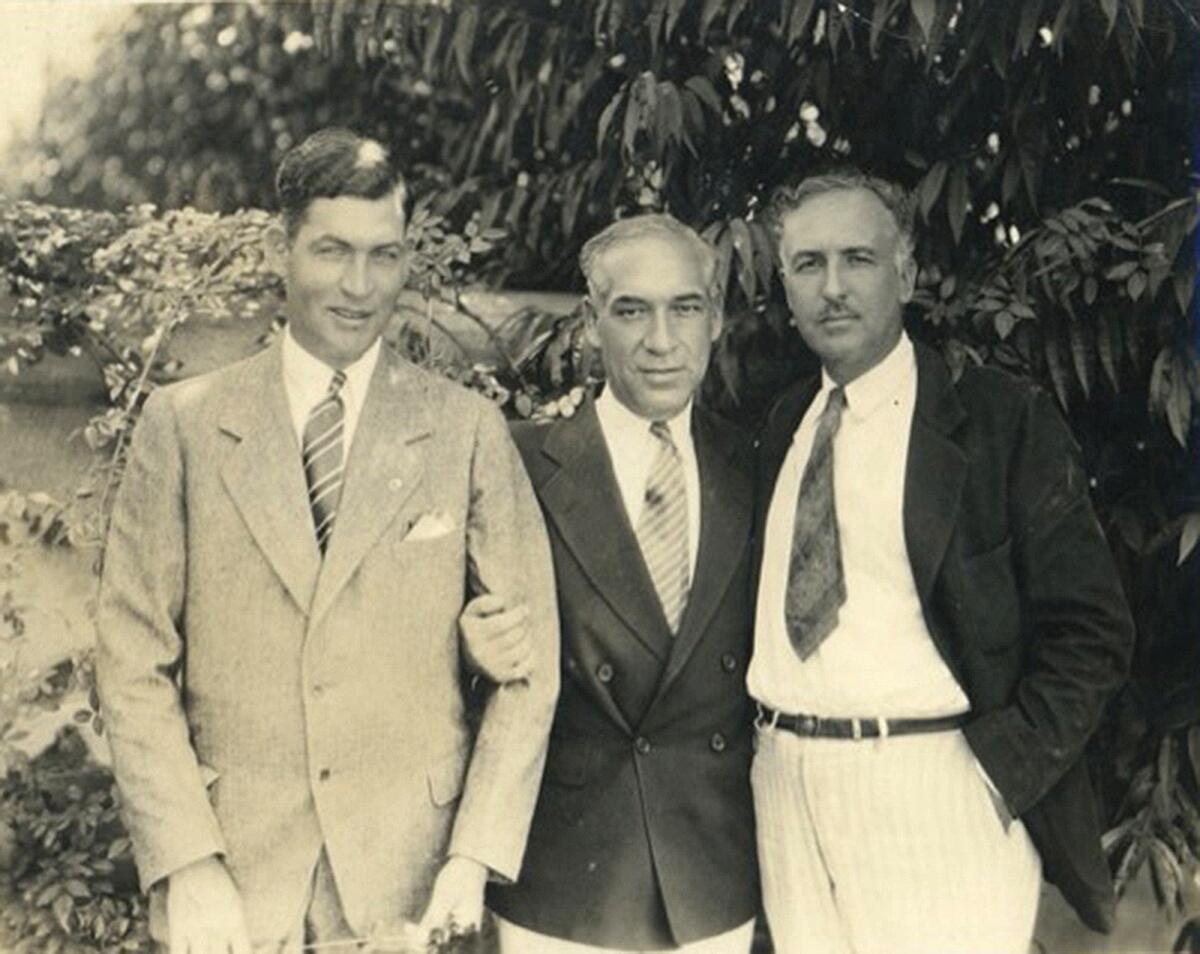 Three men pose for a photo