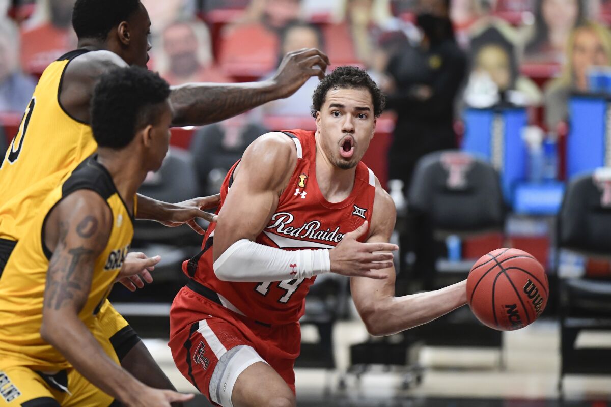 Texas Tech's Marcus Santos-Silva (14) attempts to pass the ball around multiple Grambling State players in the first half of an NCAA college basketball game in Lubbock, Texas, Sunday, Dec. 6, 2020. (AP Photo/Justin Rex)