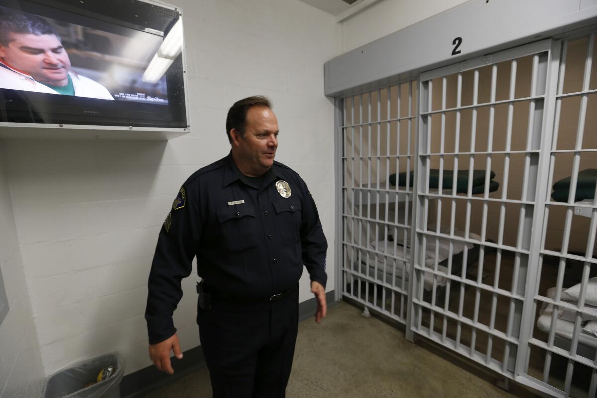 Sgt. Bowles walks past a jail cell dorm for pay-to-stay inmates. Seal Beach’s small city jail has amenities that include flat-screen TVs, a computer room and new beds.