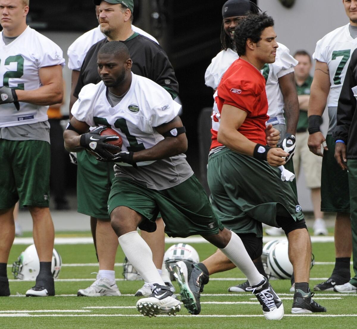LaDainian Tomlinson takes a handoff from Mark Sanchez during New York Jets training camp back in 2010.