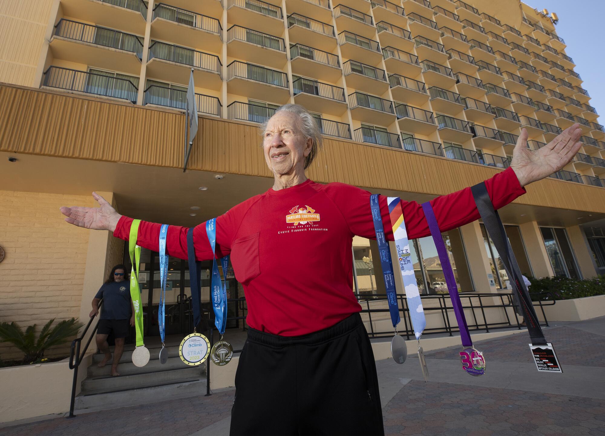 A man standing in front of a hotel that a four-race media hangs from every hand.