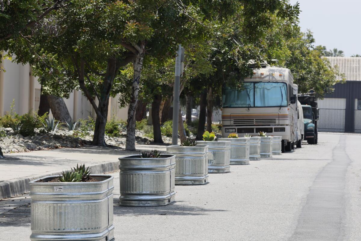 A line of metal planter boxes on the street where RVs often were parked.