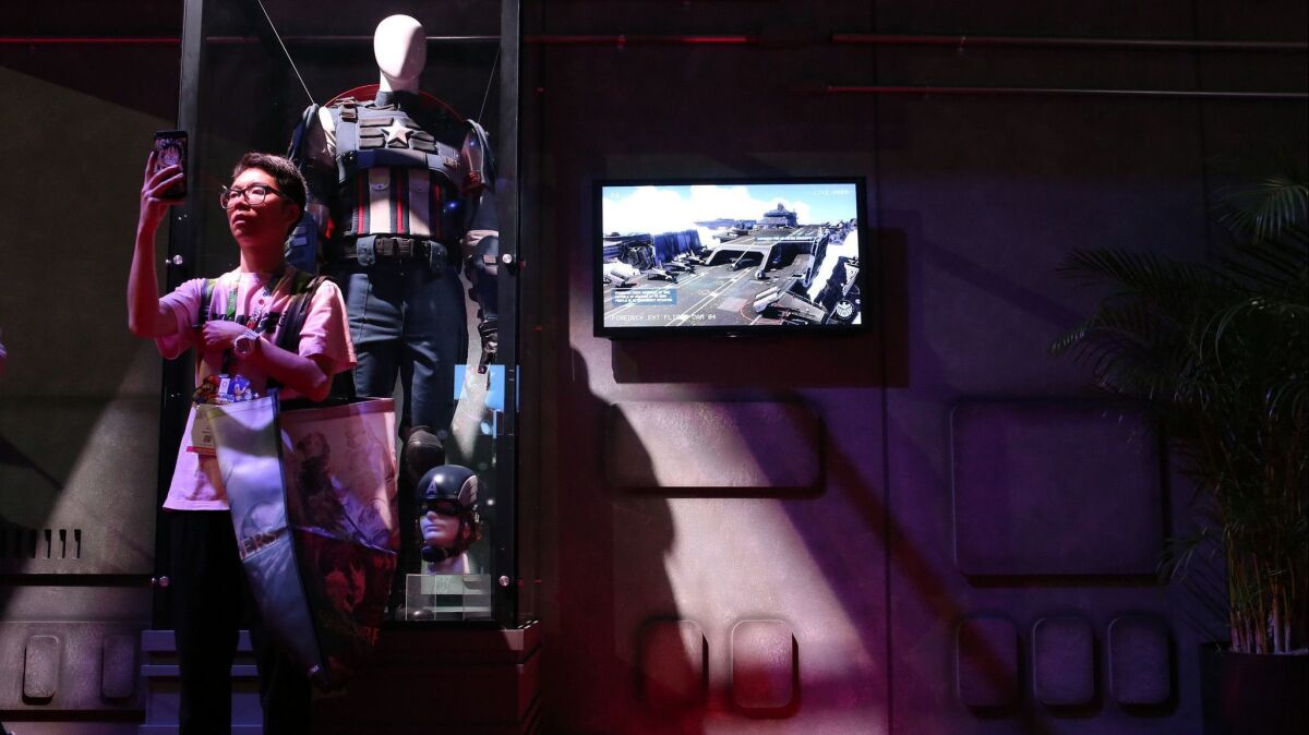 Jimmy Guan takes a picture in the Avengers booth during E3.