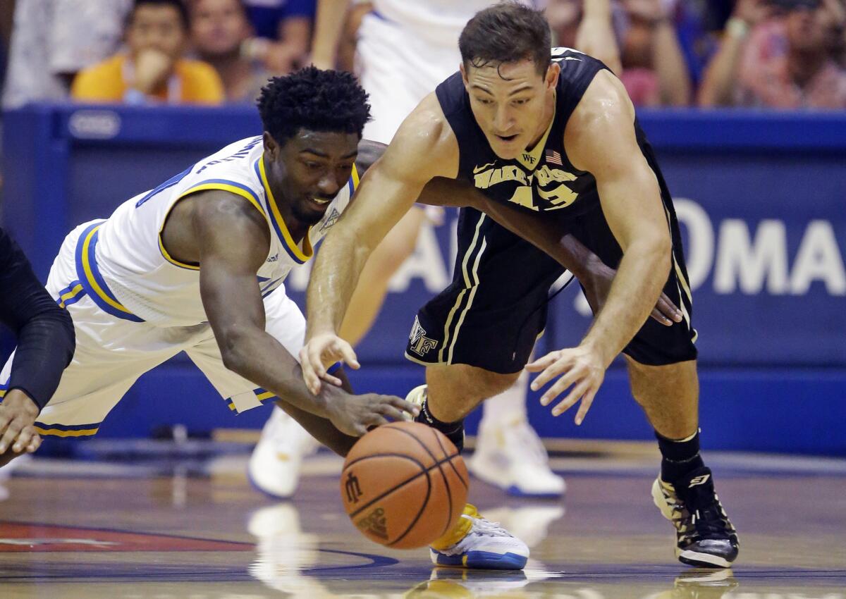 UCLA guard Isaac Hamilton, left, battles with Wake Forest guard Trent VanHorn (43) for a loose ball in the first half.