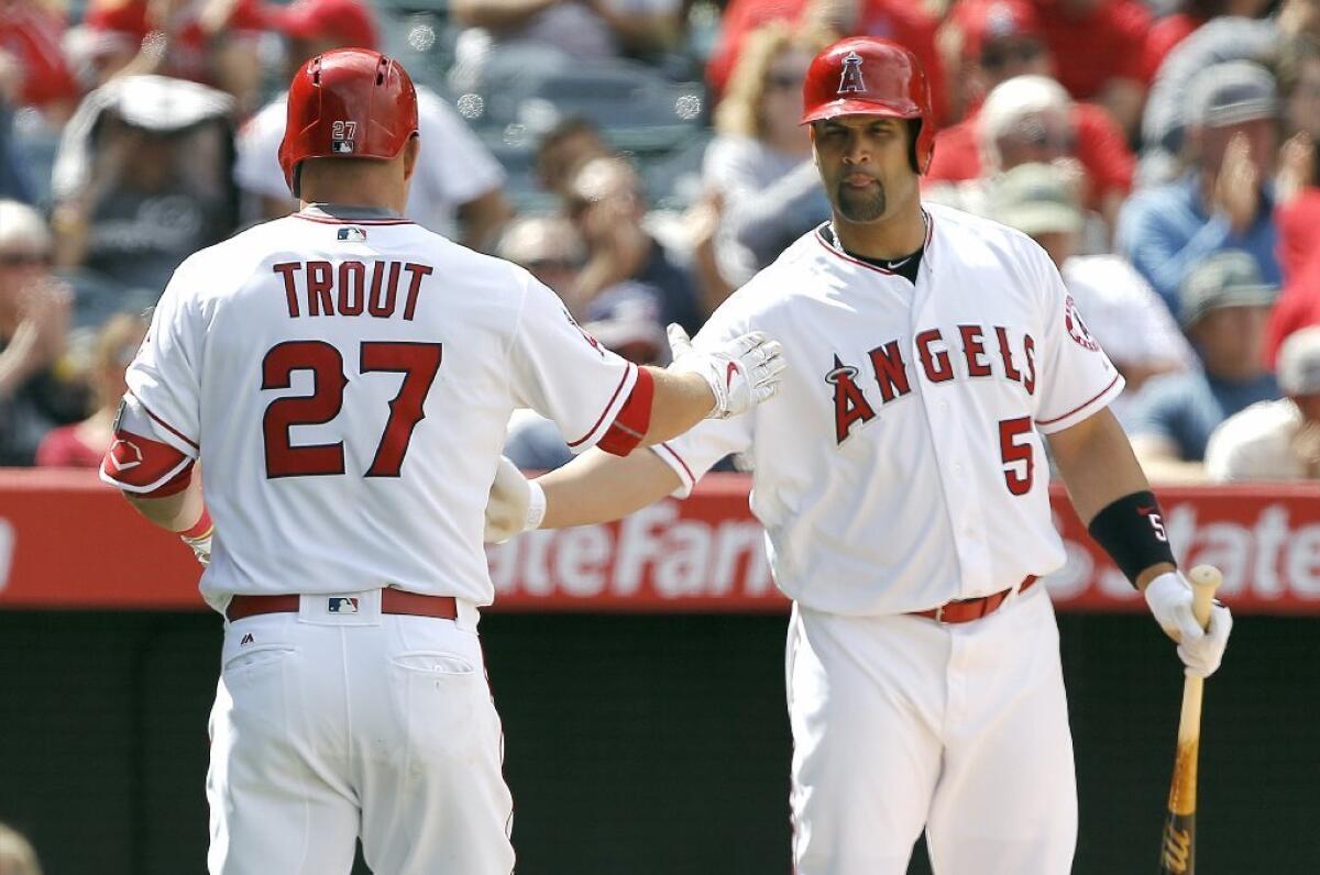 Albert Pujols (5) congratulates Mike Trout (27) after he drove in a run with a sacrifice-fly during a game against the Rangers on April 10.