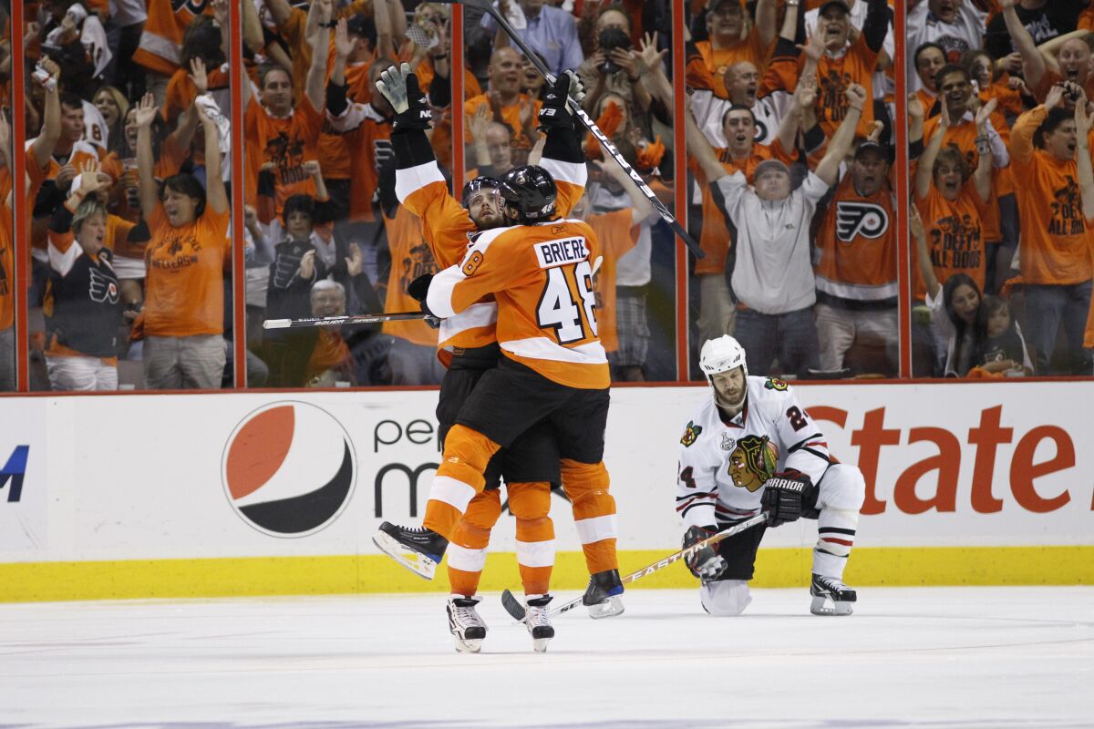 FILE - Philadelphia Flyers left wing Ville Leino (22), of Finland, celebrates his goal with Danny Briere (48) against the Chicago Blackhawks in the third period of Game 4 of the NHL Stanley Cup hockey finals on Friday, June 4, 2010, in Philadelphia. At right is Chicago Blackhawks defenseman Nick Boynton (24). Briere led the Flyers to the Stanley Cup Final in 2010. Now, he's tasked with doing it again, only from the front office. (AP Photo/Matt Slocum, File)