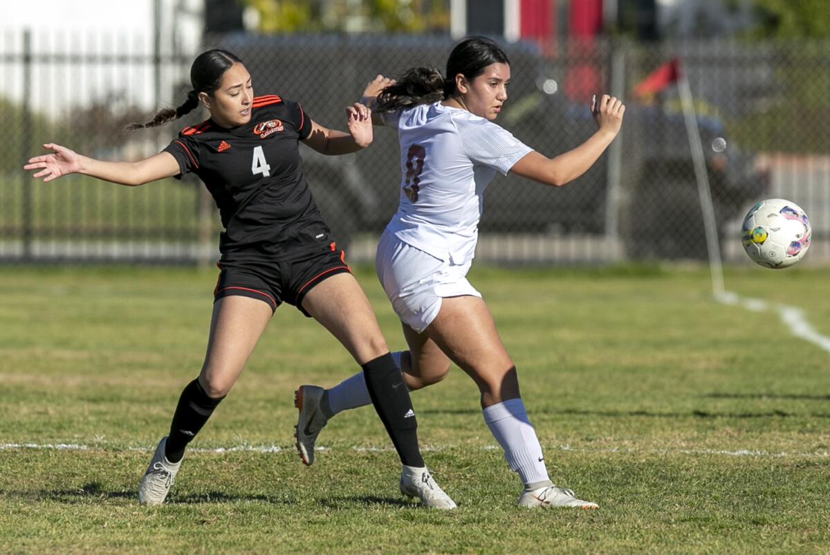 Los Amigos' Dalia Zapata battles for a ball with Estancia's Makayla Muniz during a CIF Division 6 wildcard round game.