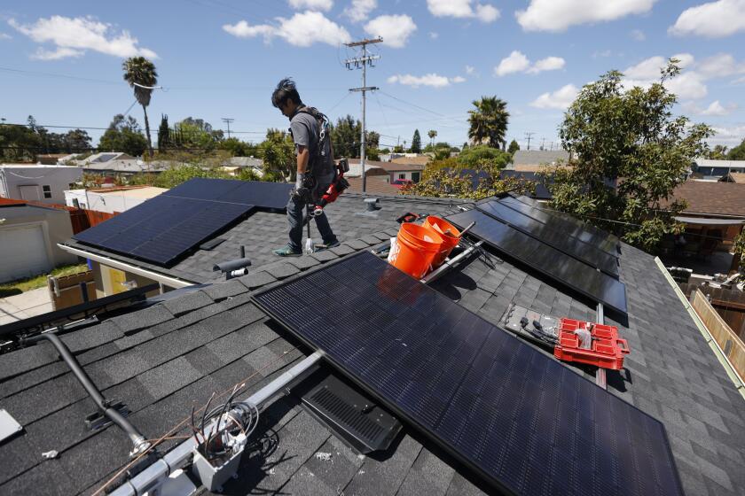 San Diego CA - April 15: Miguel Cornelio of Stellar Solar works on a solar panel installation in North Park on Monday, April 15, 2024 in San Diego, CA. (K.C. Alfred / The San Diego Union-Tribune)
