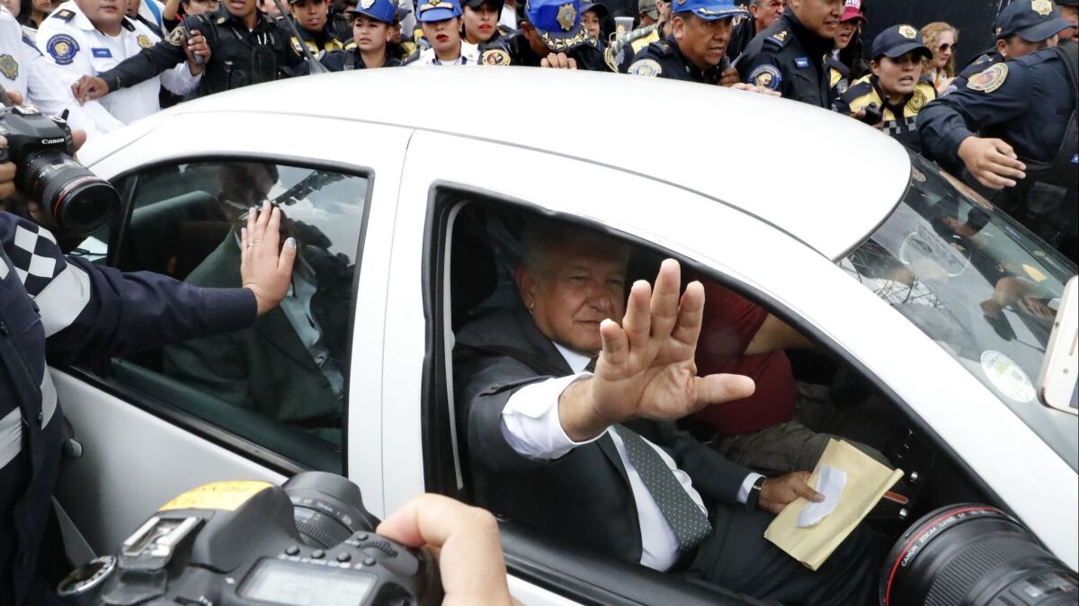 In Mexico City, Andres Manuel Lopez Obrador waves from his Volkswagen sedan.