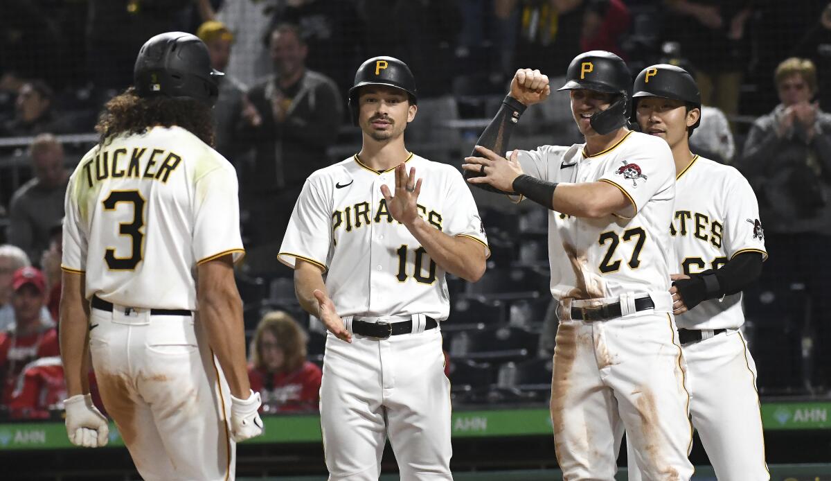 Pittsburgh Pirates' Cole Tucker (3) celebrates with teammates Bryan Reynolds (10), Kevin Newman (27), and Hoy Park (68) after hitting a grand slam against the Cincinnati Reds during a baseball game in Pittsburgh, Friday, Oct. 1, 2021. (AP Photo/Philip G. Pavely)