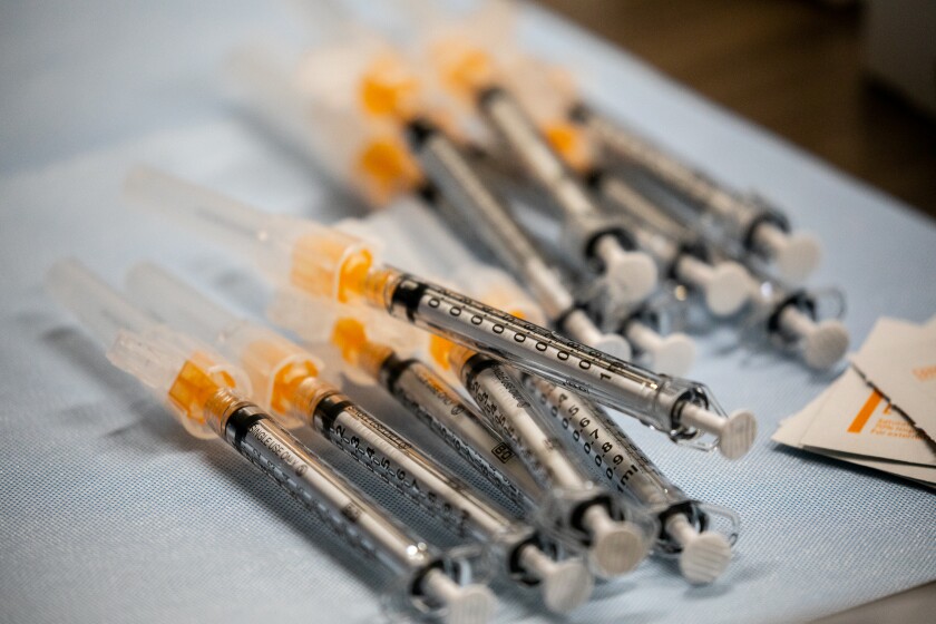 Staff prepare syringes of the Pfizer COVID-19 vaccine at Scripps Memorial