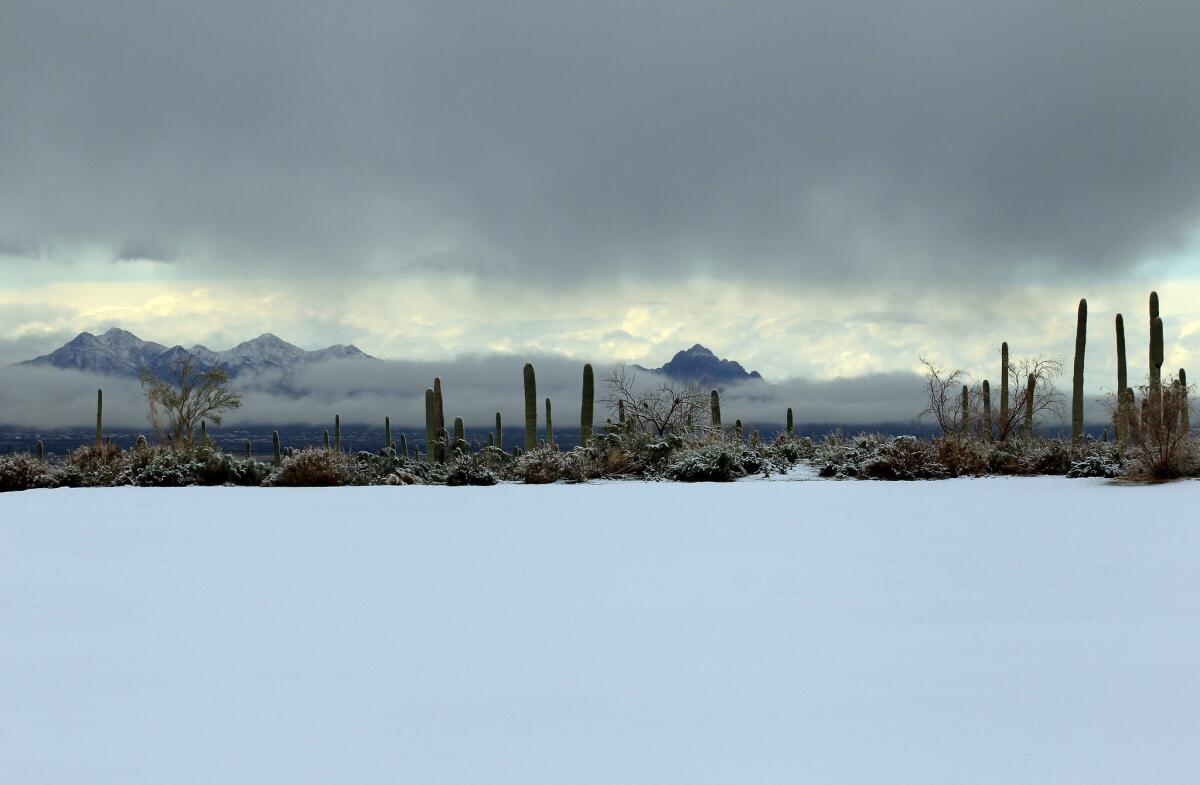 Snow covers the driving range as play was suspended during the first round of the World Golf Championships - Accenture Match Play at the Golf Club at Dove Mountain in Marana, Ariz.