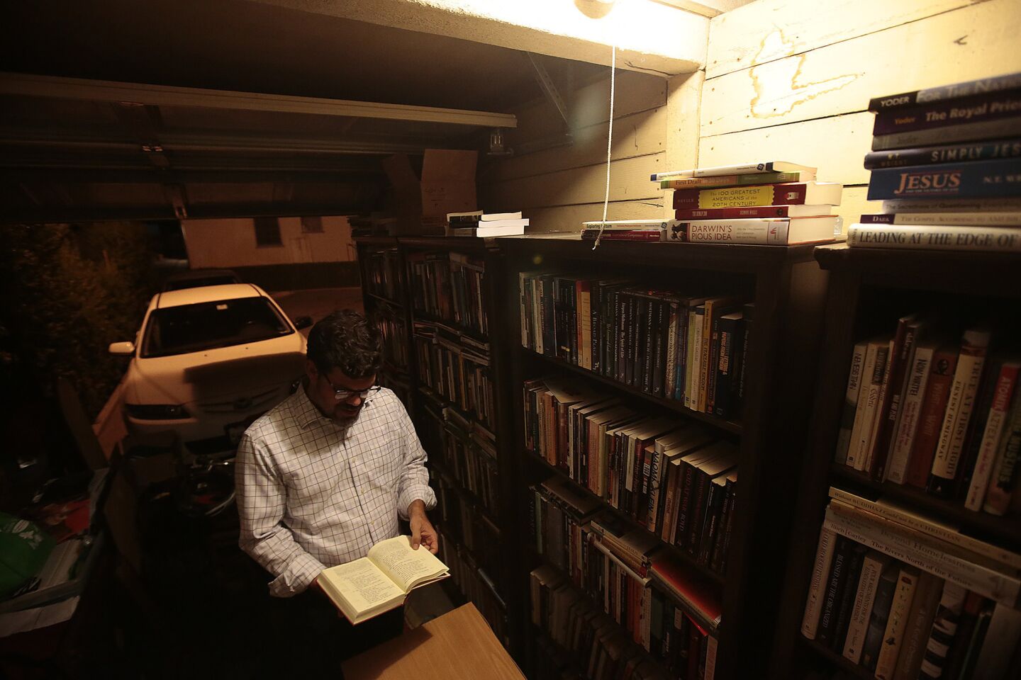 A voracious reader, Ryan Bell stands amid his book collection at his Pasadena apartment. The storm of attention after he turned his back on God took Bell by surprise. Within a week, he was explaining himself on CNN, NPR and the BBC.