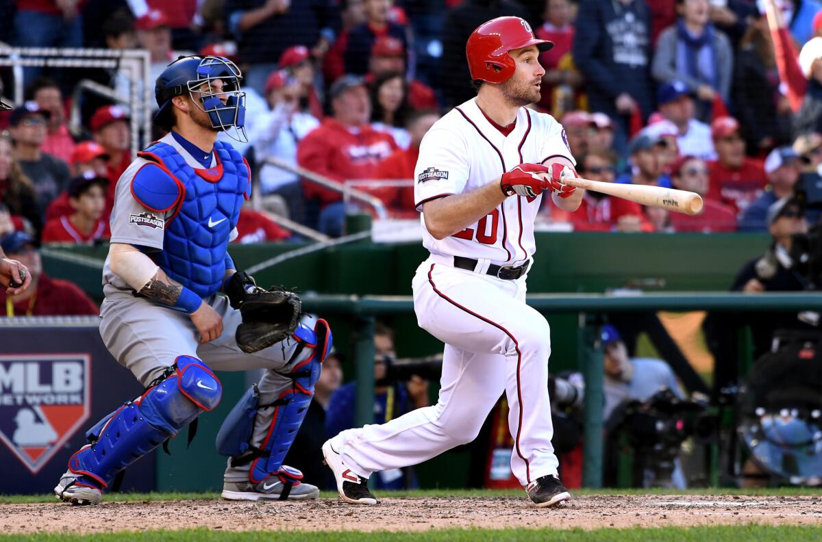 Nationals second baseman Daniel Murphy gets a hit in front of Dodgers catcher Yasmani Grandal.