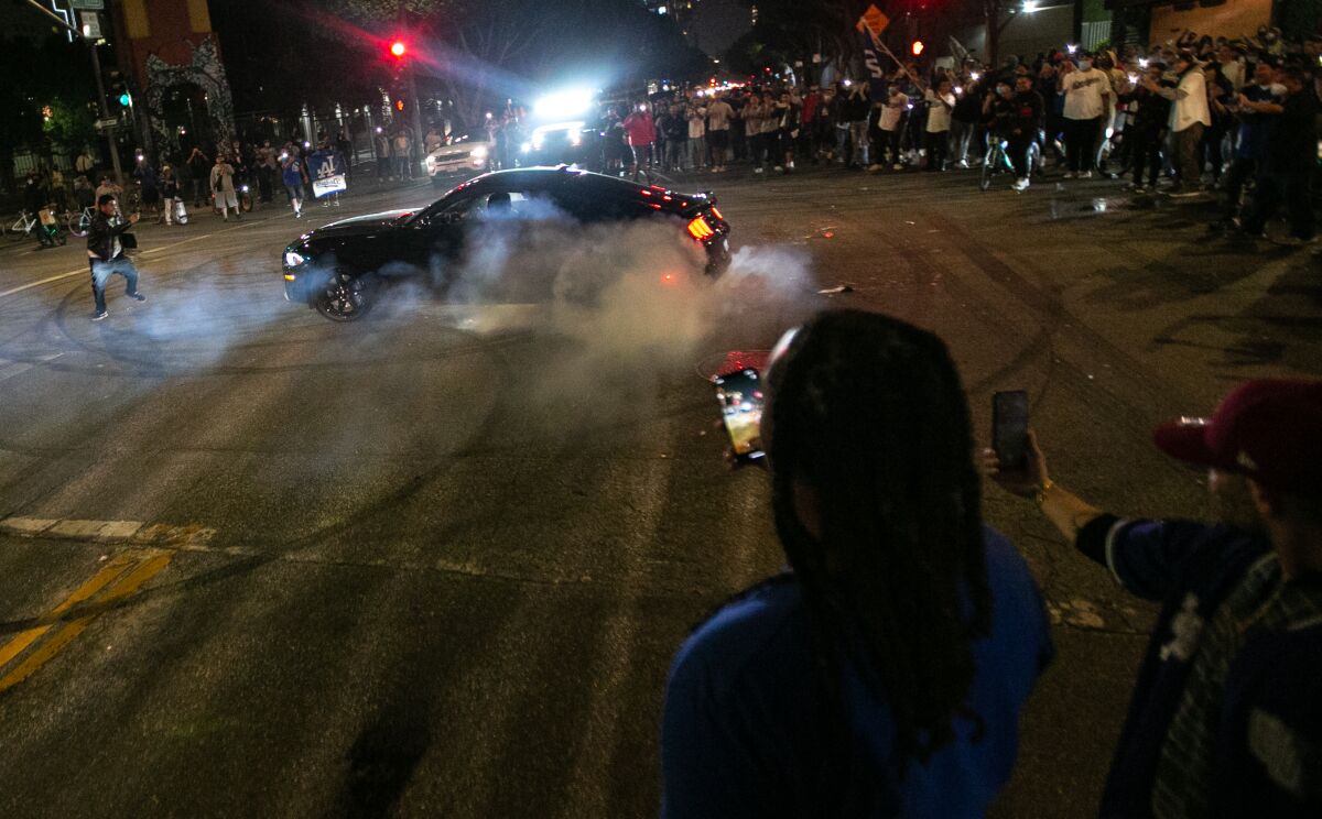 Fans watch a car doing burnouts as they celebrate