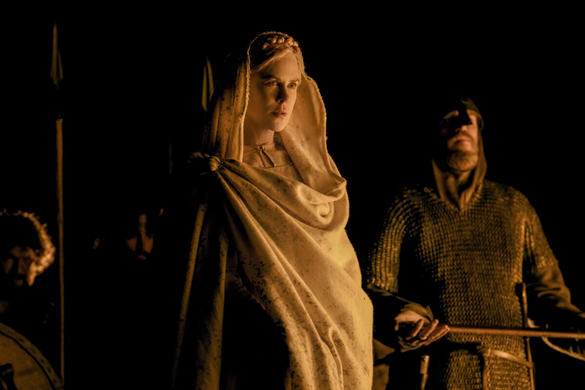 A woman and guard in Medieval garb.