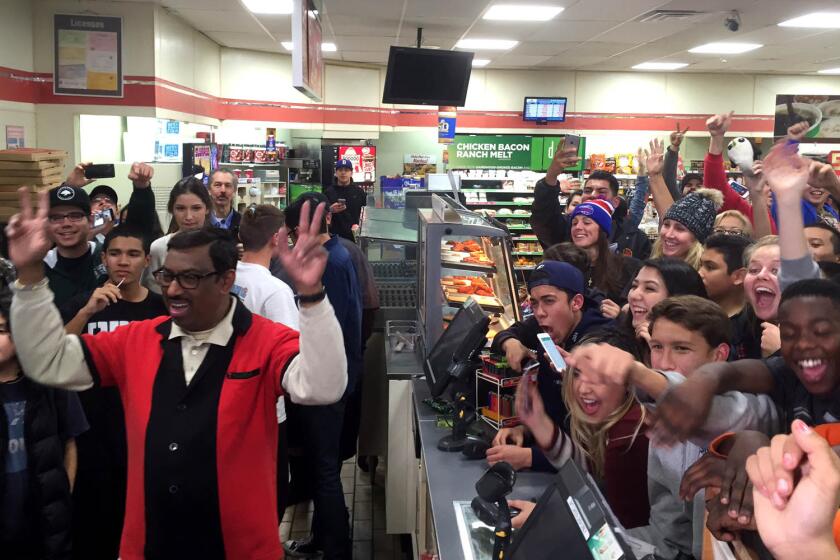 M. Faroqui, left, celebrates the sale of a winning Powerball ticket at a 7-Eleven in Chino Hills.