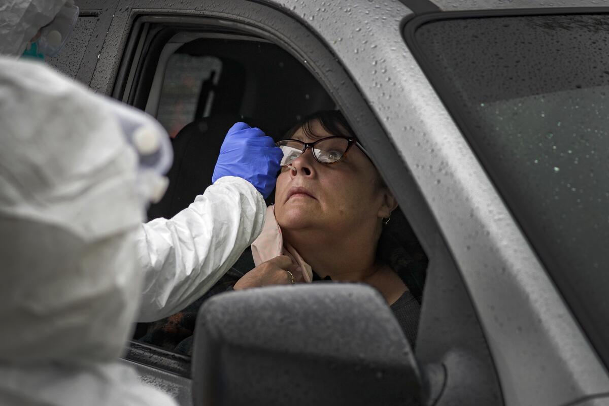 Julie Montez sits in her car as a nurse administers a COVID-19 test at Arrowhead Regional Medical Center in Colton in April.