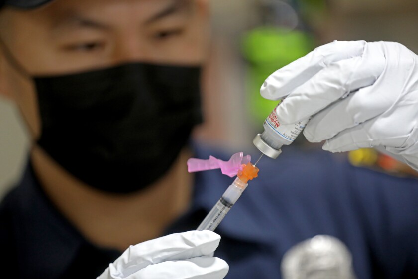 Anthony Kong of the Los Angeles Fire Department prepares a dose of COVID-19 vaccine. 