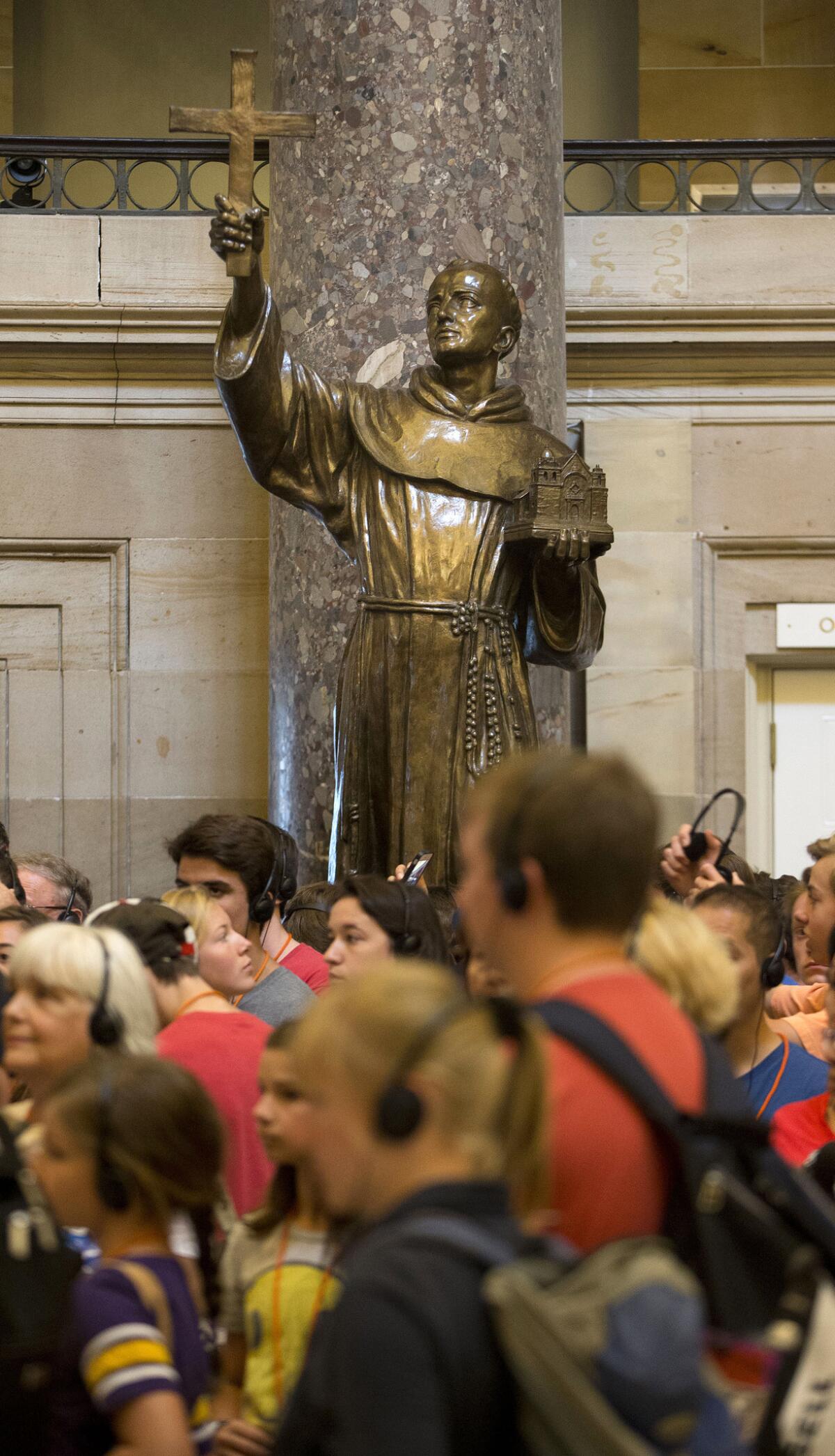 En esta imagen de archivo, tomada el 2 de julio de 2015, visitantes en el Capitolio pasan junto a una estatua del misionero Junípero Serra (centro), ubicada en el Statuary Hall, en el Capitolio, Washington. (Foto AP/Pablo Martinez Monsivais, archivo)