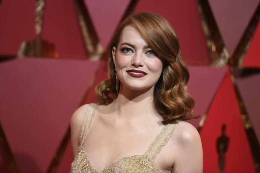 Emma Stone poses with curled red hair and nude, sequined dress at the 2017 Oscars