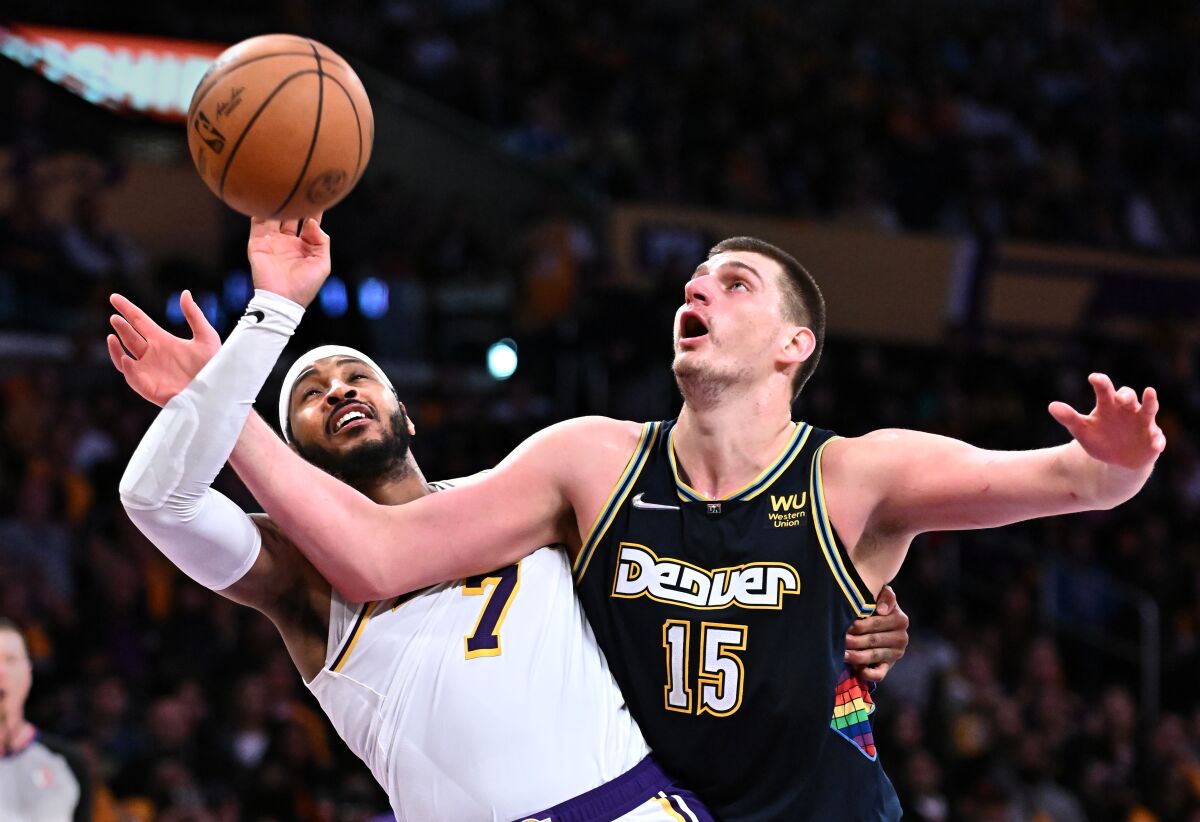 Lakers forward Carmelo Anthony and Nuggets center Nikola Jokic battle for a rebound.