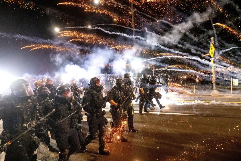 FILE - In this Sept. 5, 2020, file photo, police use chemical irritants and crowd control munitions to disperse protesters during a demonstration in Portland, Ore. New York, Seattle and Portland, three cities recently labeled "anarchist jurisdictions" by the U.S. Justice Department, are suing to to invalidate the designation and to fight off the Trump administration's efforts to withhold federal dollars. The lawsuit, filed, Thursday, Oct. 22, 2020 in U.S. District Court in Seattle, ridiculed Trump's action as offensive to the Constitution and common sense, but said the consequences of withholding federal money during a pandemic "are deadly serious." (AP Photo/Noah Berger, File)