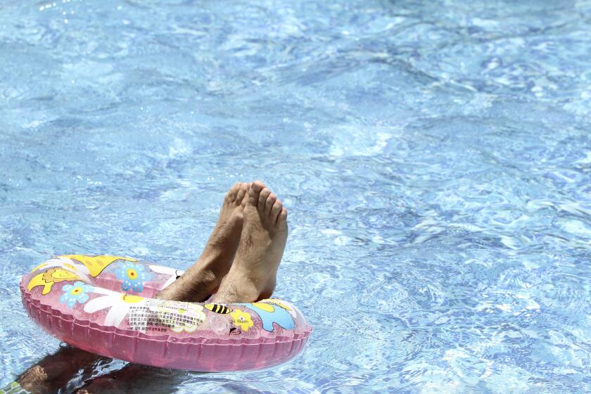 A man cools down in a swimming pool at Taipei Water Museum in Taipei, Taiwan, Saturday, July 19, 2014. (AP Photo/Chiang Ying-ying)