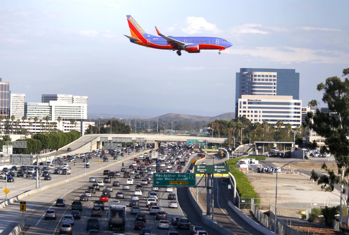 A Southwest Airlines plan flies over the 405 Freeway as it approaches the runway at John Wayne Airport.